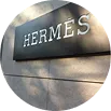 Placa exterior de Hermès sobre fachada de piedra.
