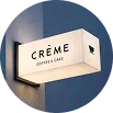 Letrero tipo bandera en crema que dice 'Crème Coffee & Cake'.