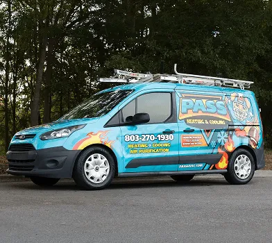 Van azul clara con wrap colorido de servicios PAS estacionada en exterior.