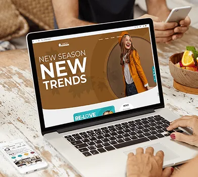 Laptop mostrando tienda online de moda con banner de temporada y compra rápida.