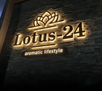 Letrero retroiluminado 'Lotus-24' en pared de piedra oscura.