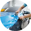 Técnico instalando vinil azul sobre la carrocería de un vehículo.
